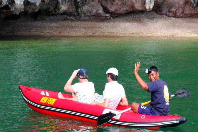 Gäste im Kanu mit Guide zwischen den Felsen der Phang-Nga-Bucht
