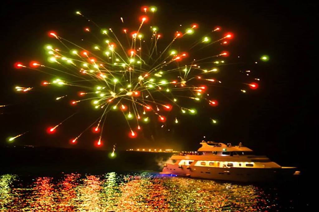 A yacht on the sea beneath a fireworks display off the coast of Cyprus