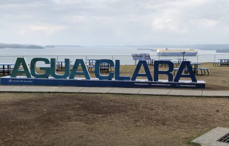 Agua-Clara-Schriftzug vor dem Gatúnsee mit Frachter
