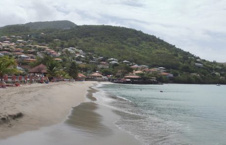 Strand Strand von Anse Mitan mit Häusern am grünen Hang