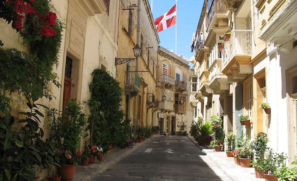Enge Altstadtgasse mit Blumen und Flaggen auf Malta Enge Altstadtgasse mit Blumen und Flaggen auf Malta