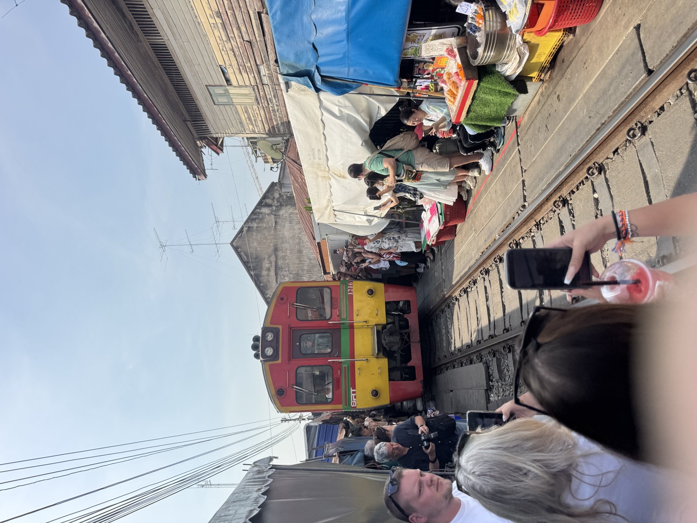 Zug fährt durch den Maeklong-Markt zwischen den Ständen Zug fährt durch den Maeklong-Markt zwischen den Ständen