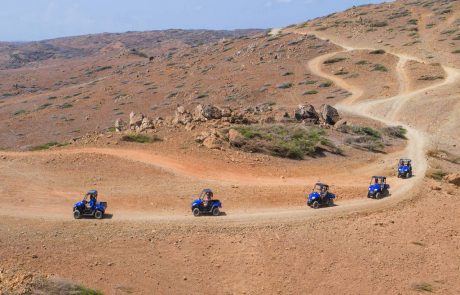 Ansicht von oben Fünf Buggys fahren durch die karge Hügellandschaft