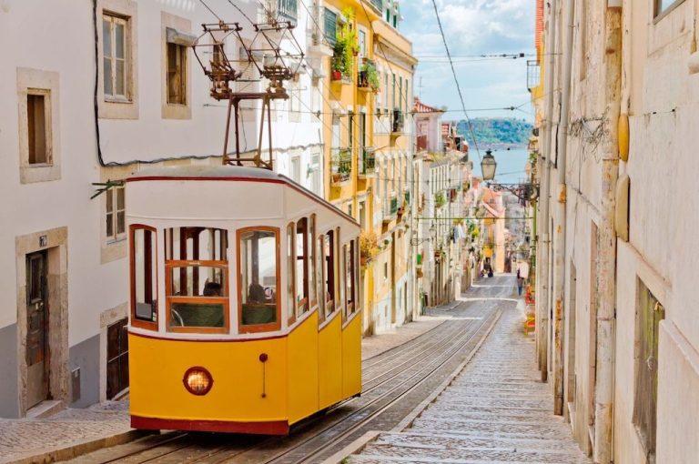 Gelbe Straßenbahn in einer engen Gasse der Lissabonner Altstadt