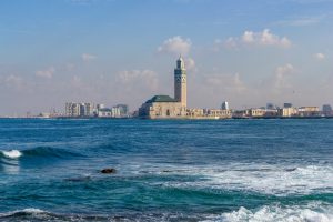 Skyline von Casablanca mit der Hassan-II.-Moschee hinter der Atlantikbrandung