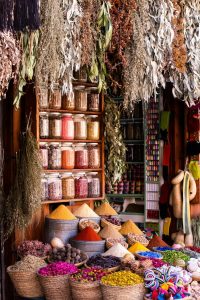 Gewürzstand im Souk mit bunten Pulverkegeln, Kräutern und Trockenblüten